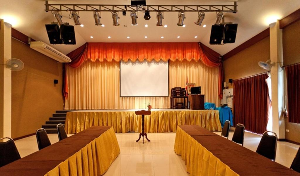 Konferenču zāle ar skatuvi, apgaismojumu un ekrānu. Zāles interjers ir elegants, ar dzeltenām un oranžām detaļām.