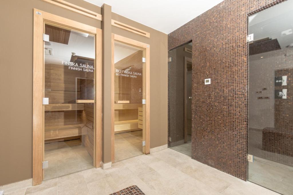 Mūsdienīga sauna ar divām durvīm, kas atdala Finskas un Bio Finskas saunas. Interjers ir elegants, ar koka akcentiem un flīzēm, radot relaksējošu atmosfēru.