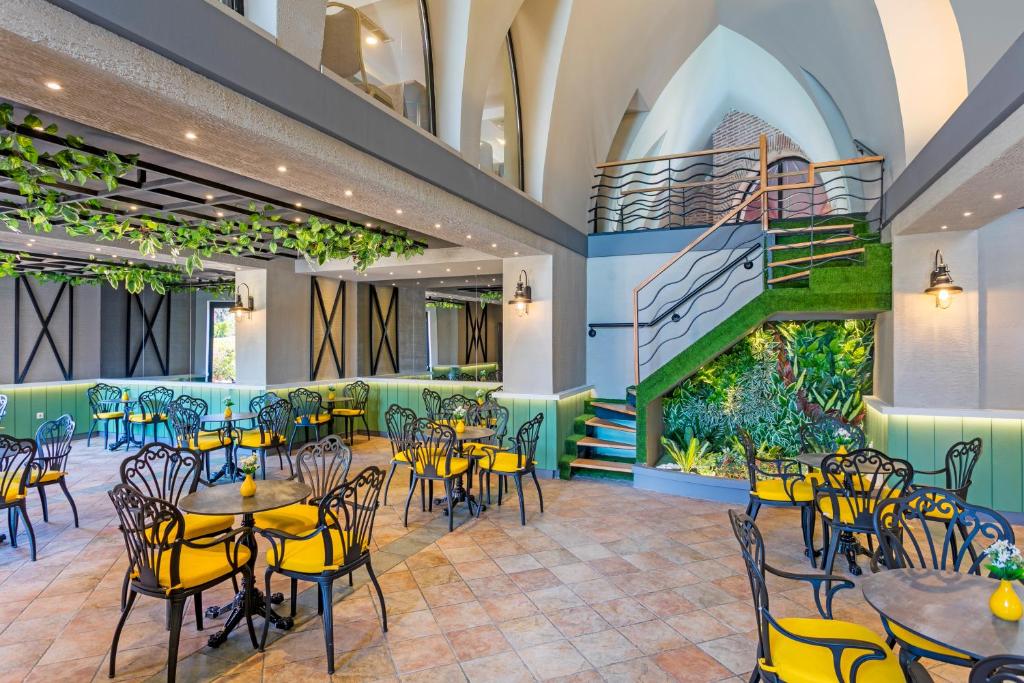 Restorāns Limak Arcadia Sport Resort ar dzeltenām krēsliem un zaļām dekorācijām.