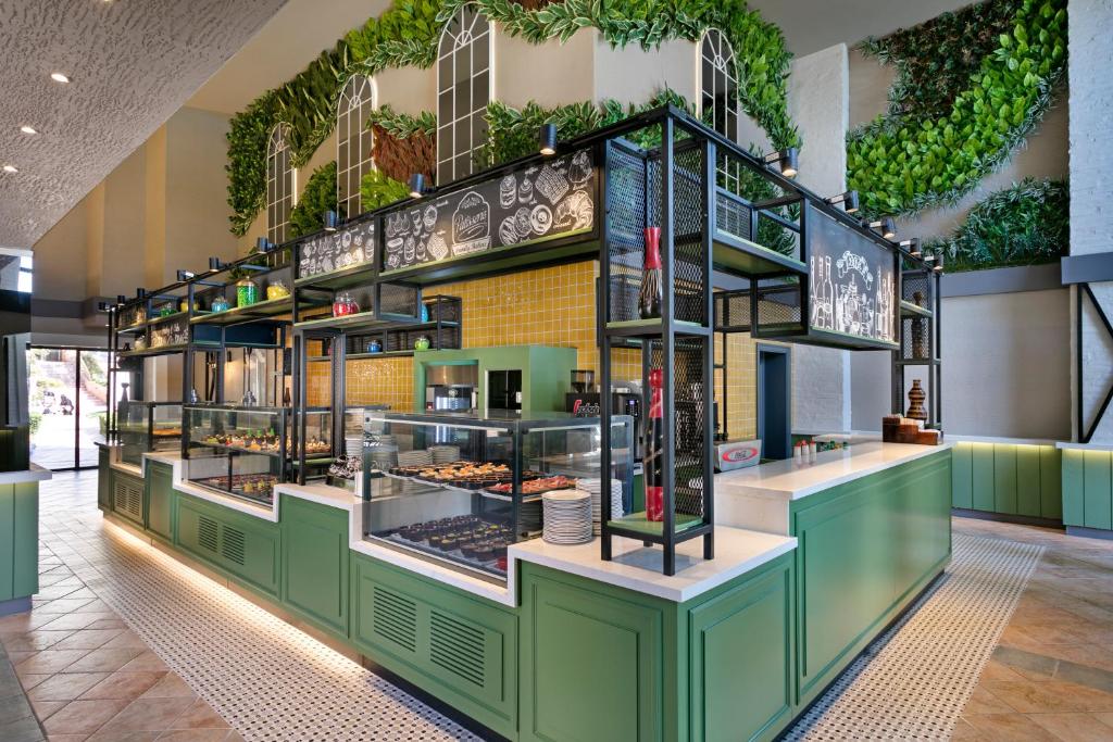 Moderna un estētiska kafejnīca Limak Arcadia Sport Resort ar zaļām dekorācijām.