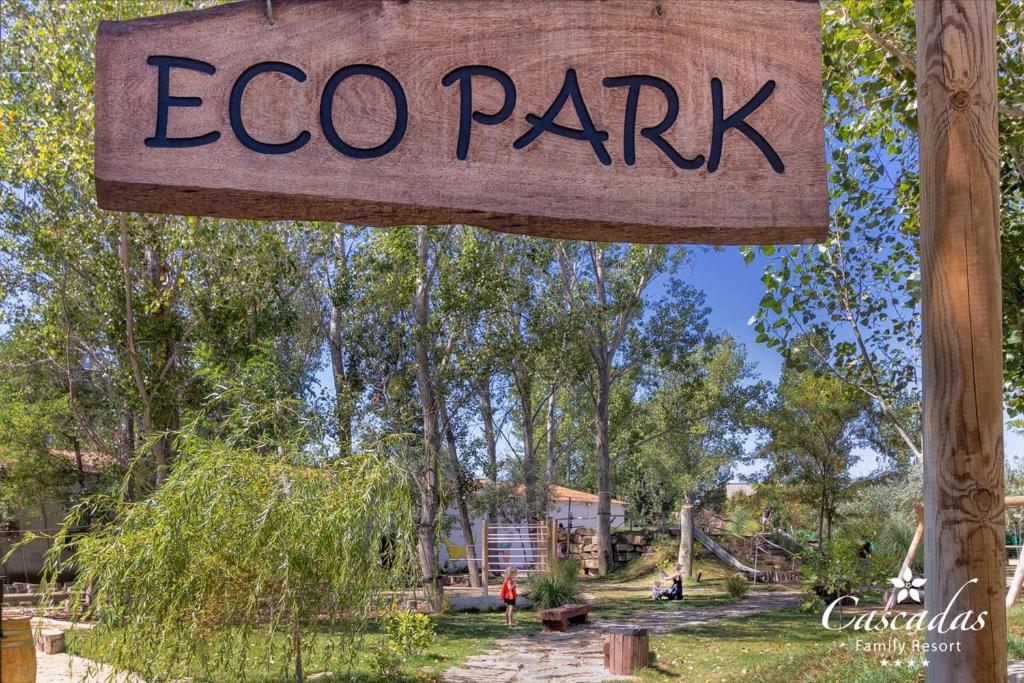 Eko parka zīme, kas norāda uz dabas un atpūtas iespēju vietu, apkārt zaļi koku un augu apstādījumi. Ideāla vieta ģimenes izklaidei un savienojumam ar dabu.