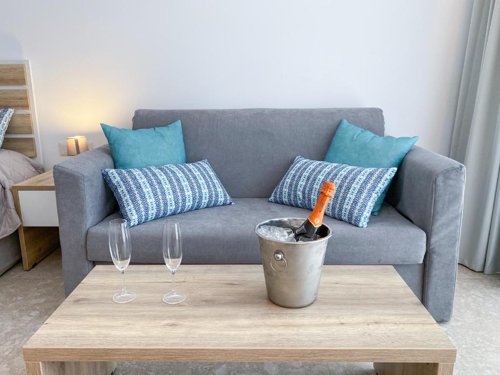 Mūsdienīgs dīvāns ar spilveniem un šampanieša pudeli Lardos Bay