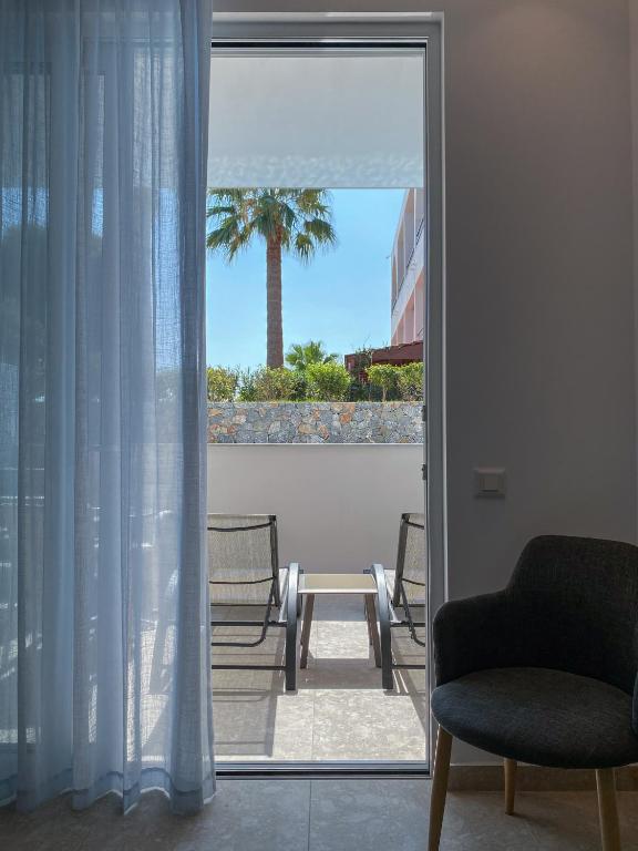 Paverums uz terasi pie Lardos Bay viesnīcas ar palmām un sauļošanās krēsliem.