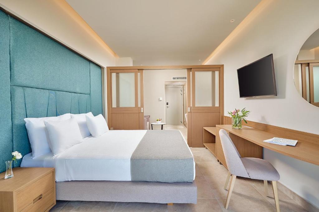 Mūsdienīgs numurs Princess Sun Hotel ar ērtu gultu un darba galdu.