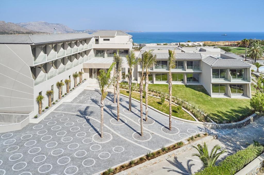Princess Sun Hotel moderna ēka piekrastē ar palmām un skaistu ainavu.