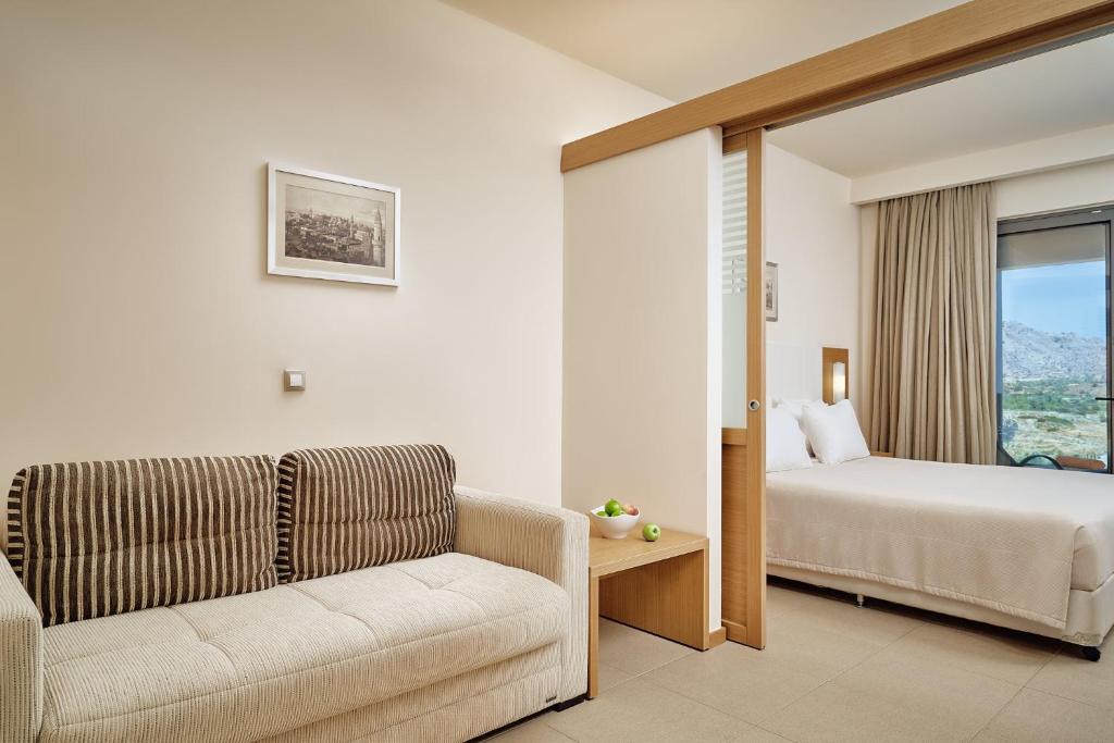 Mūsdienīgs numurs Princess Sun Hotel ar dīvānu un skatu uz dabu.