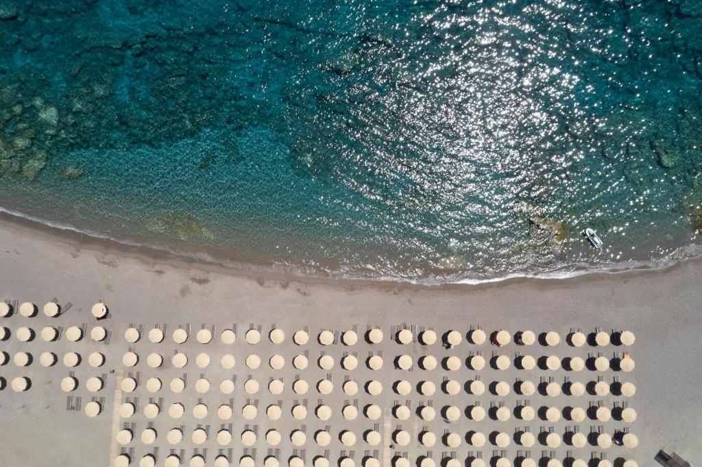 Princess Sun Hotel pludmale ar saules krēsliem un skaidru ūdeni