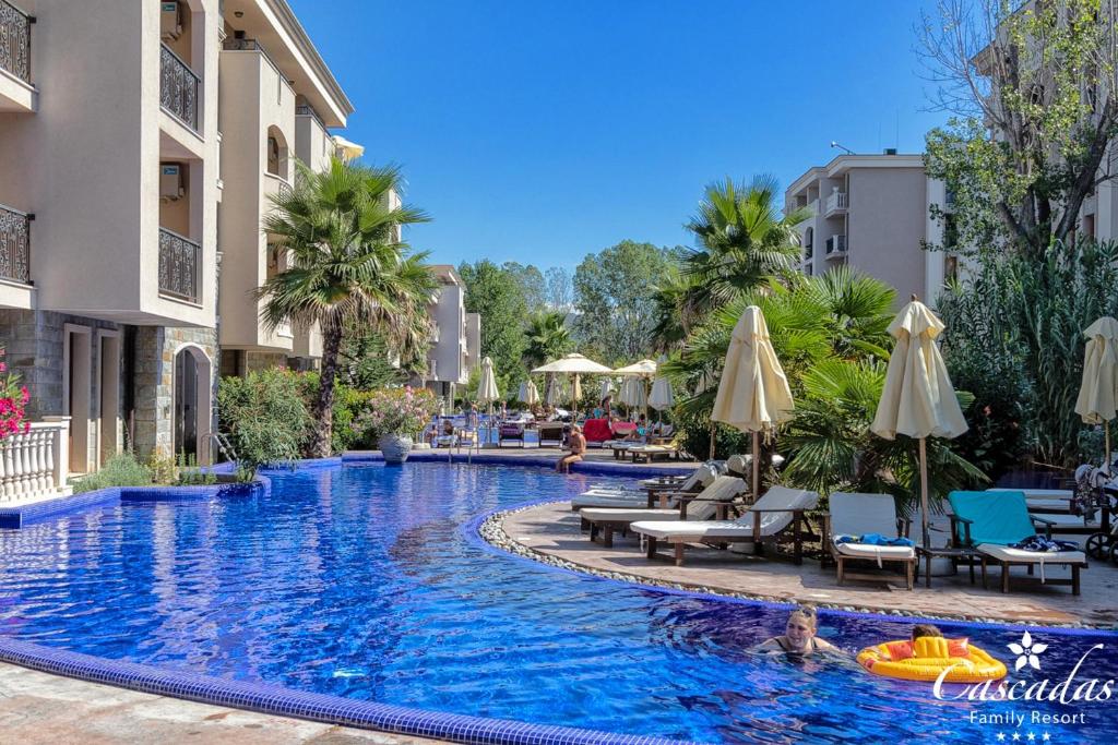 Lieliska pludmales viesnīca ar baseinu, saules gultām un palmu kokiem, kas rada relaksējošu atmosfēru. Ideāla vieta ģimenes atpūtai un izklaidei.