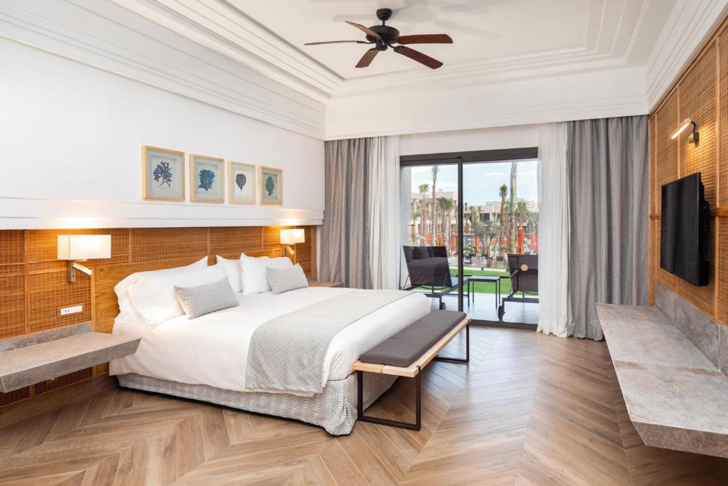 Mūsdienīgs viesnīcas numurs ar plašu gultu, koka paneļu sienām un dabiskiem akcentiem. No numura paveras skats uz dārzu un terasi.