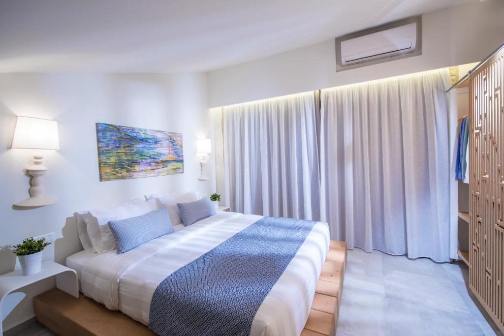 Mūsdienīgs guļamistabas interjers ar ērtiem gultas piederumiem, mākslas darbu pie sienas un logu aizkaru, kas nodrošina dabīgu apgaismojumu.