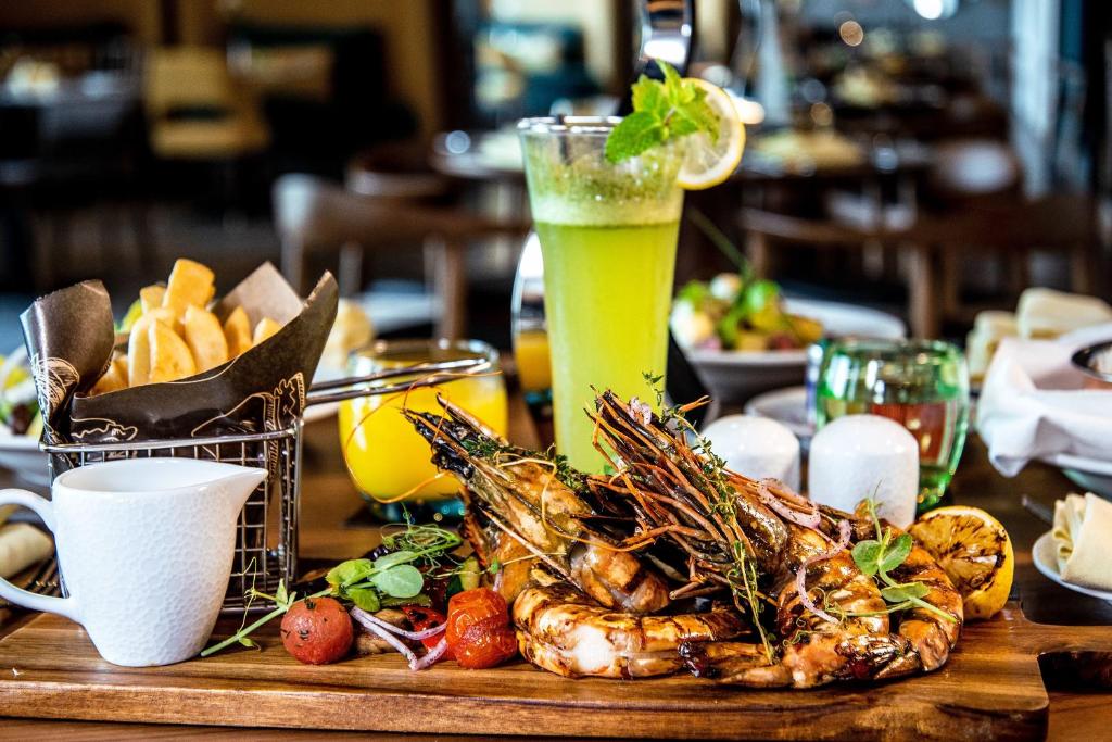 Garšīgs jūras velšu ēdiens ar garnelēm, dārzeņiem un svaigu dzērienu uz galda. Ideāla izvēle gardēžiem.