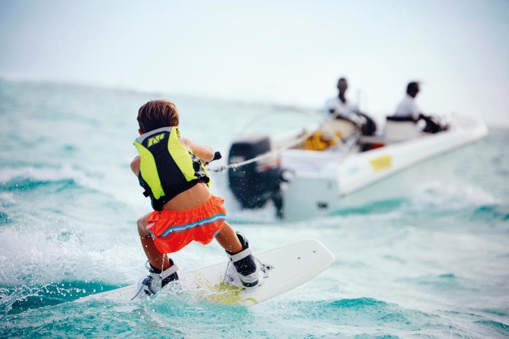 Bērns, kas kaitsē piekrastē pie LUX* Le Morne, baudot ūdens priekus.