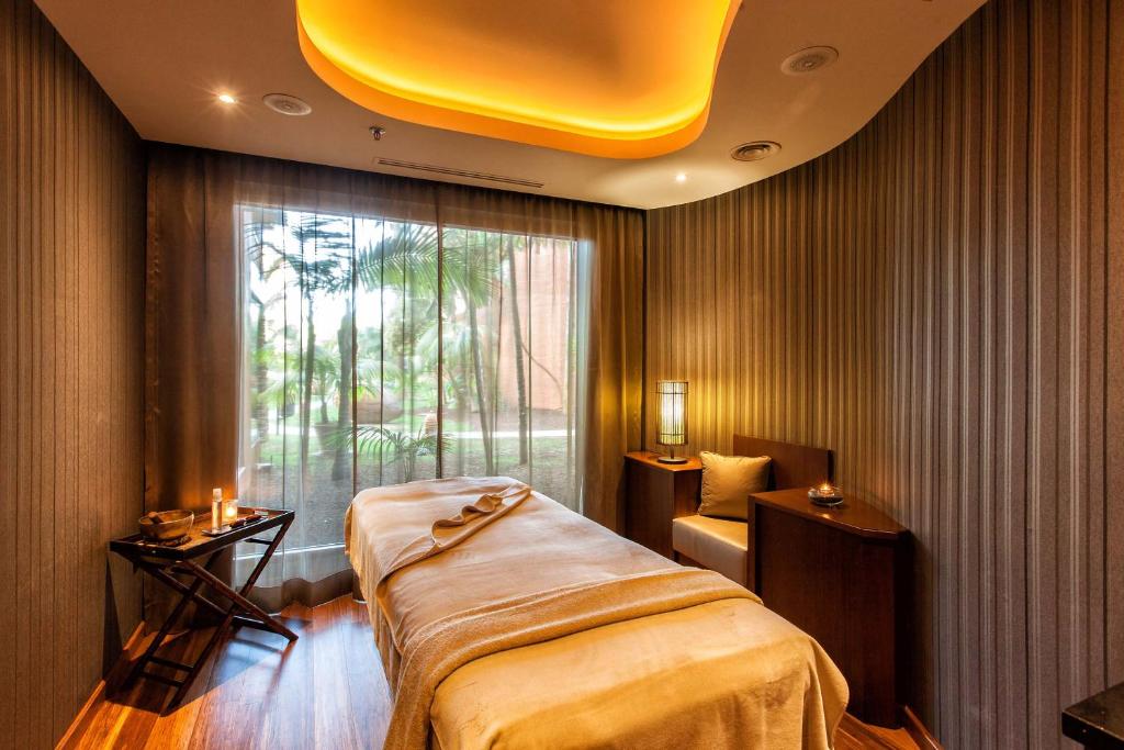 Mūsdienīgs spa telpa ar relaksējošu atmosfēru, kurā ir masāžas gulta, dabiska gaisma un eleganta apdare. Ideāla vide relaksācijai un atjaunošanai.