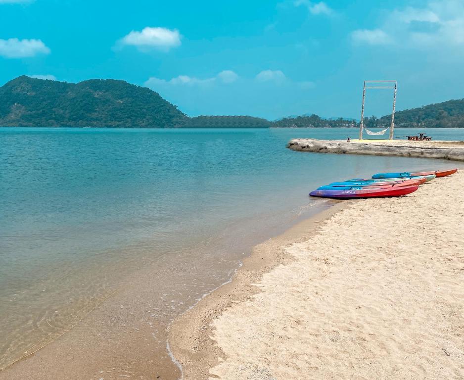 Piekraste pie The Aiyapura Koh Chang Resort ar kajakiem un skaistu ūdeni.