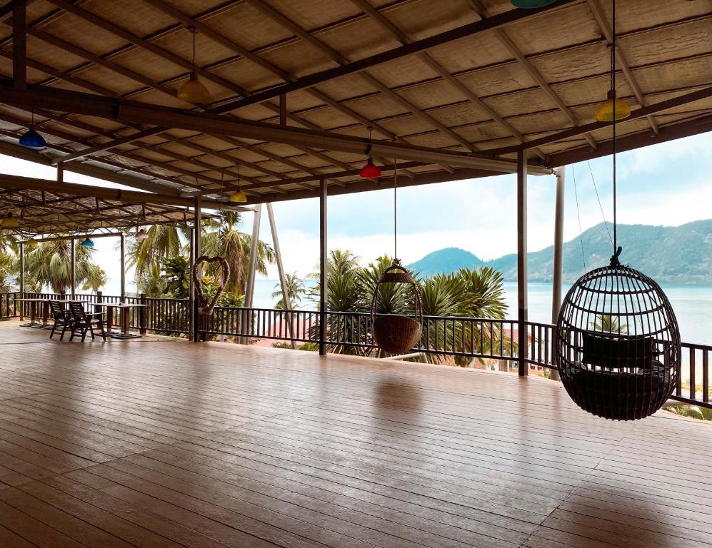 Plaša terase ar šūpuļkrēslām pie The Aiyapura Koh Chang Resort, skats uz jūru.