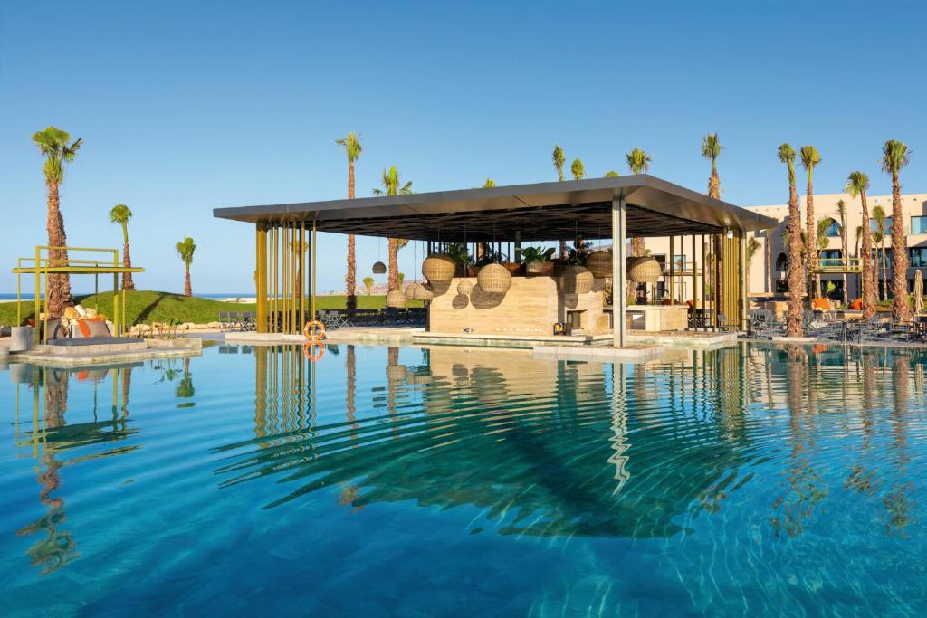 Mūsdienīgs baseina bārs ar palmām ap to, atspoguļojoties dzidrajā ūdenī. Ideāla vieta atpūtai un relaksācijai.