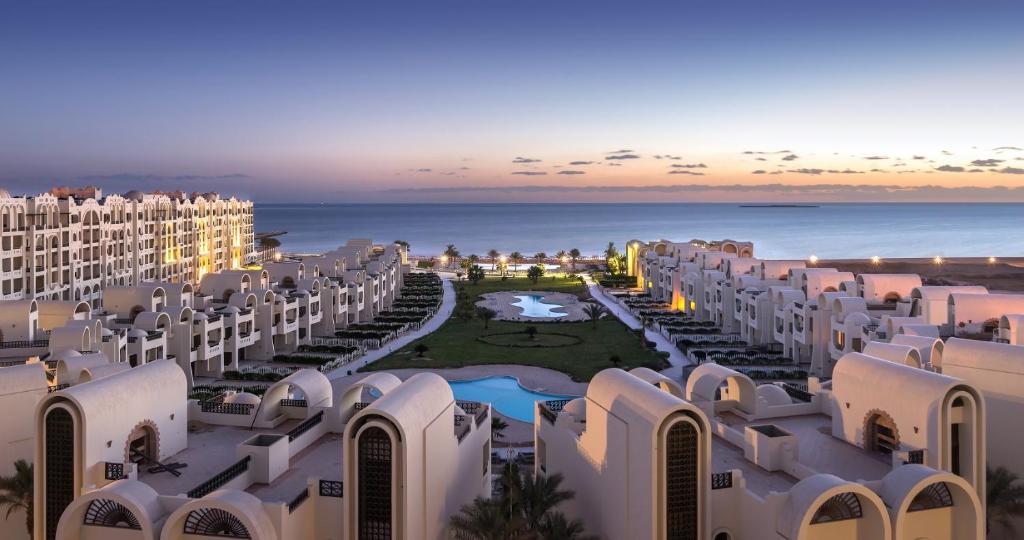 Gravity Hotel Sahl Hasheesh piekrastes skats ar baseinu un viesnīcu kompleksu saulrietā