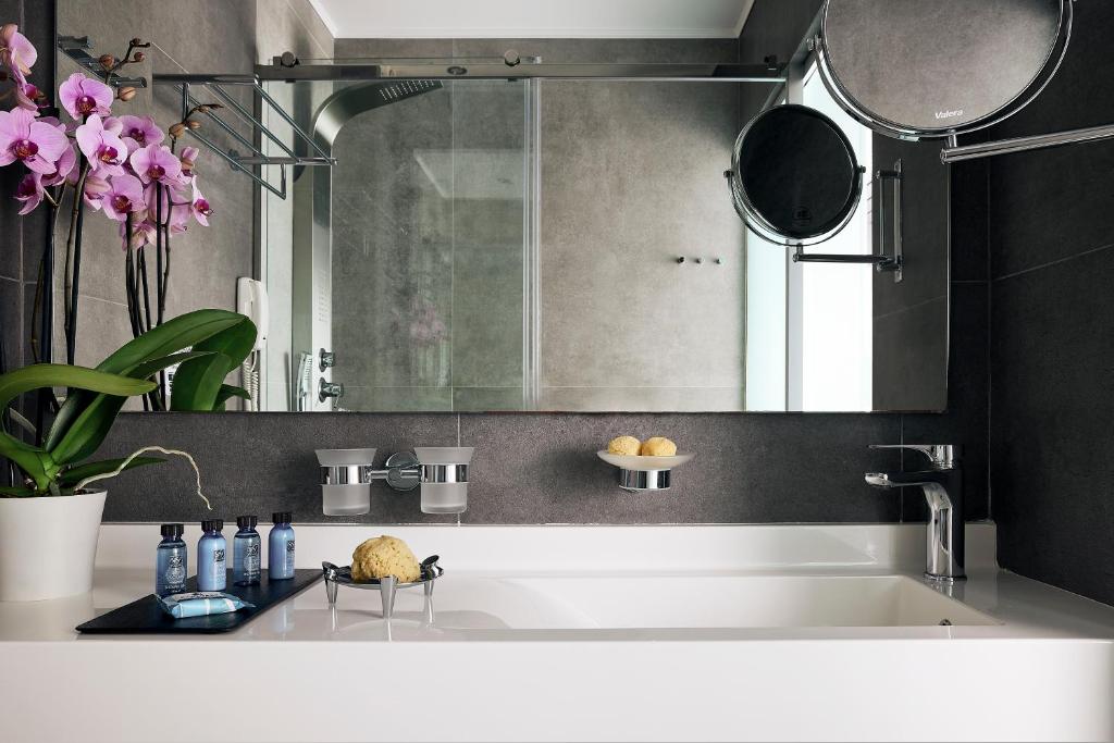 Mūsdienīgs vannas istabas interjers ar orhidejām, higiēnas produktiem un elegantu vannu. Estētiski pievilcīgas detaļas, kas radītas relaksējošai atmosfērai.