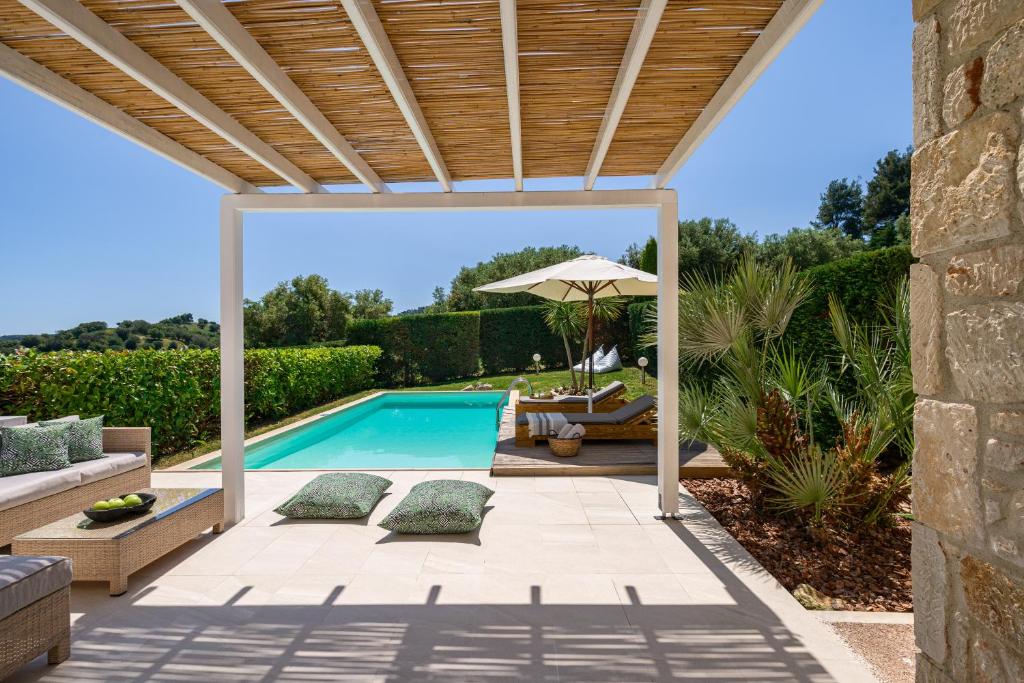 Mūsdienīgs āra atpūtas zonas skats ar peldbaseinu, sauļošanās krēslām un zaļiem augiem. Ideāla vieta atpūtai saulainā dienā.