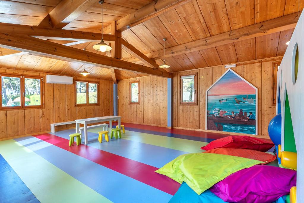 Krāsaina bērnu spēļu istaba ar koka apdari un mīkstajiem pufiem AP Victoria Sport & Beach Hotel