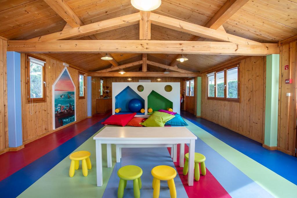 AP Victoria Sport & Beach Hotel bērnu spēļu istaba ar krāsainu grīdu un koka apdari.