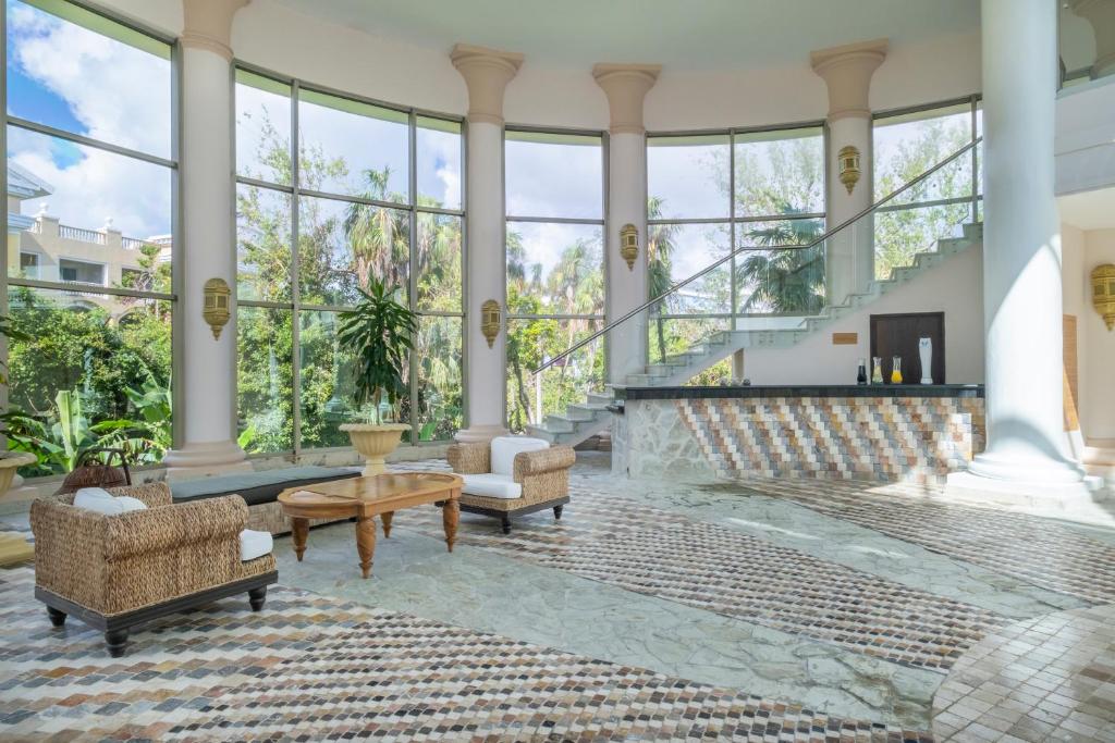 Elegantais vestibilis pie JOIA Paraiso by Iberostar ar stikla sienām un zaļumu skatu.