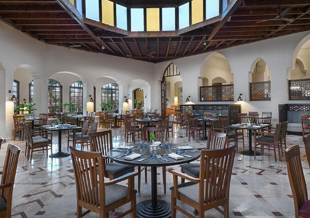 Iberotel Makadi Beach restorāns ar elegantiem galdiem un koka griestiem