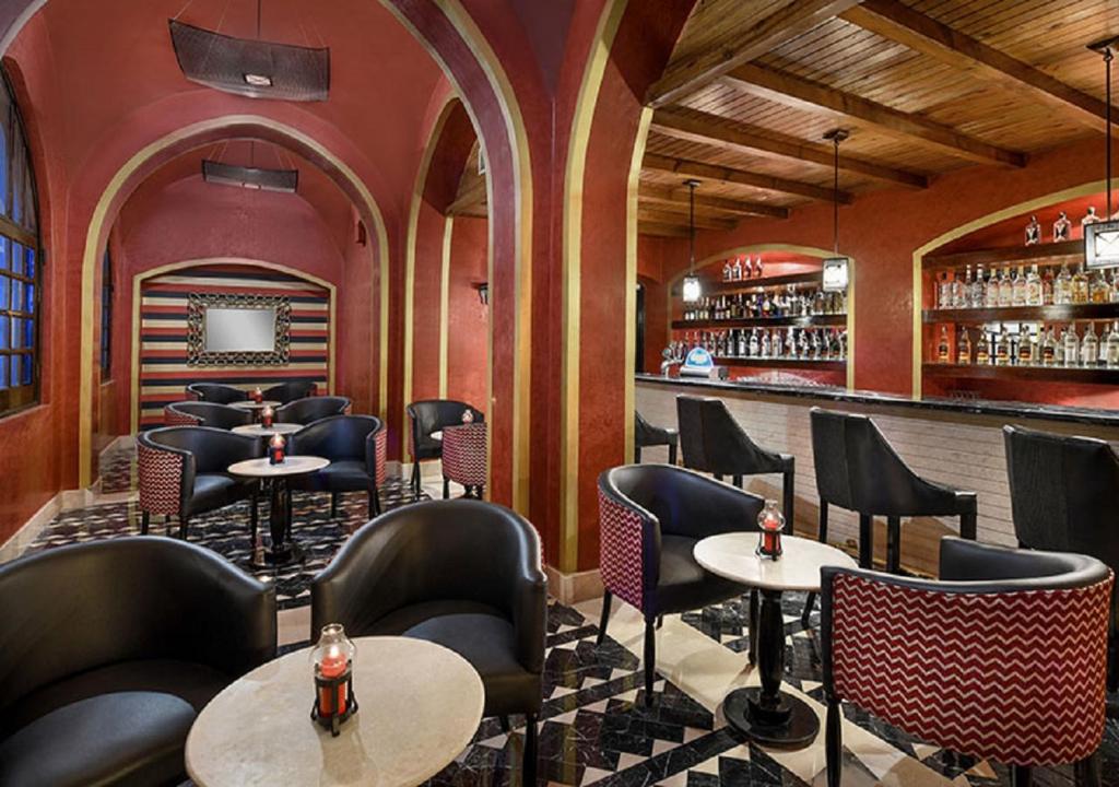 Elegants bārs Iberotel Makadi Beach ar melnām krēslām un sarkanu apdari.