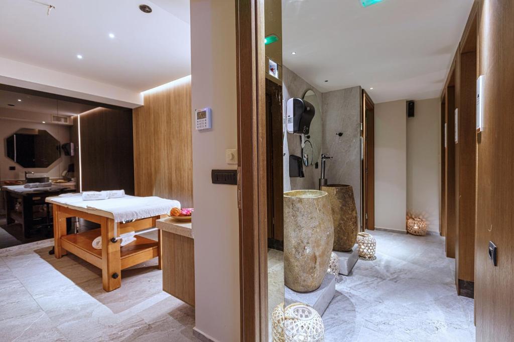 Mūsdienīgs spa interjers ar masāžas galdu un akmens dekorācijām, radot relaksējošu atmosfēru. Svaigu augļu un dekoratīvo elementu klātbūtne papildina kopējo estētiku.