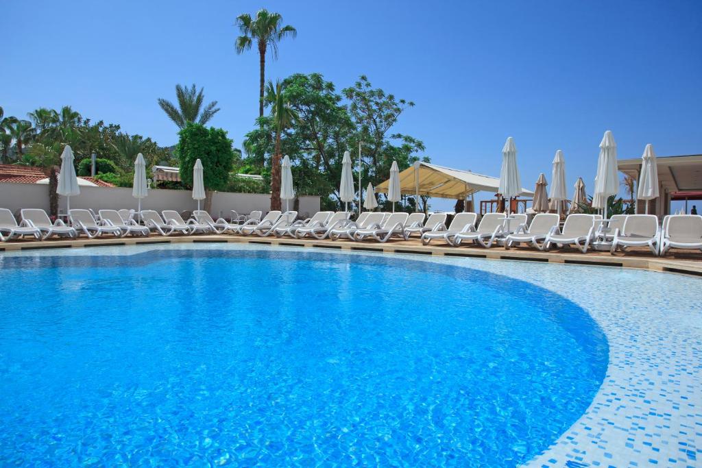 Viesnīcas Xperia Saray Beach baseins ar sauļošanās krēsliem piekrastē