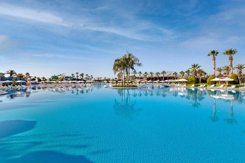 Miracle Resort Hotel peldbaseins ar palmām un saulessargiem