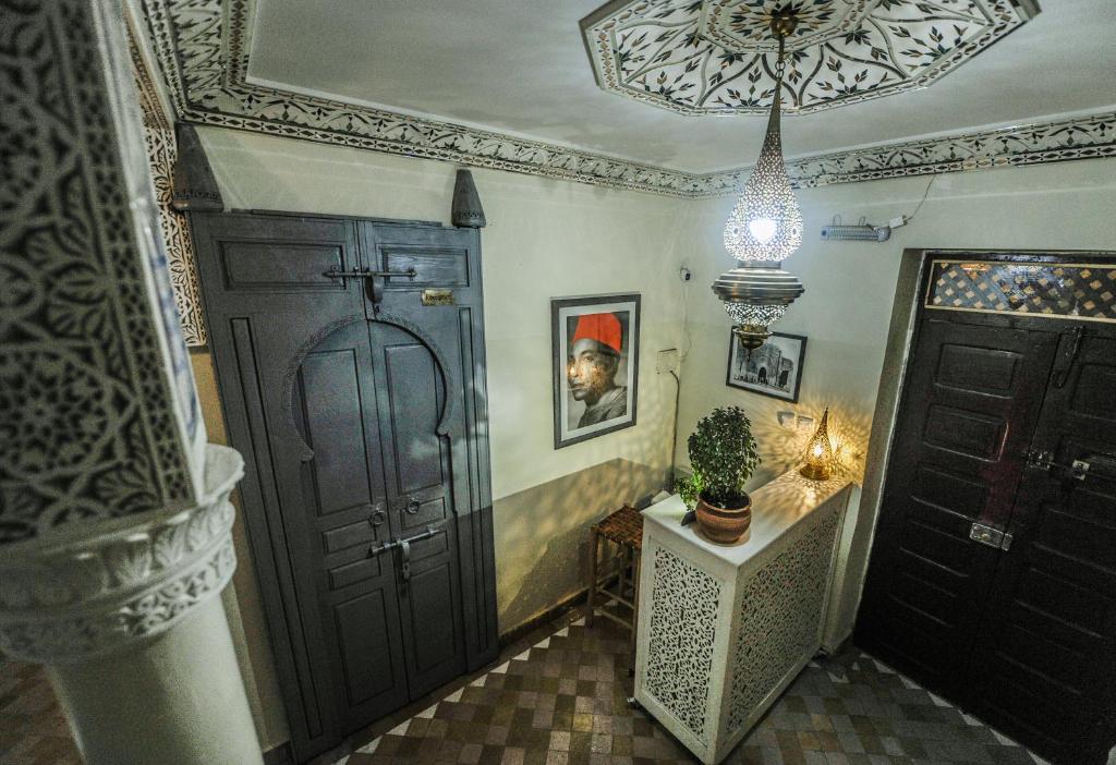 Eleganta interjera ar tradicionālo dekori un gaismas elementiem, kas rada siltu atmosfēru. Redzama arī mākslas gleznas un augs uz galda.