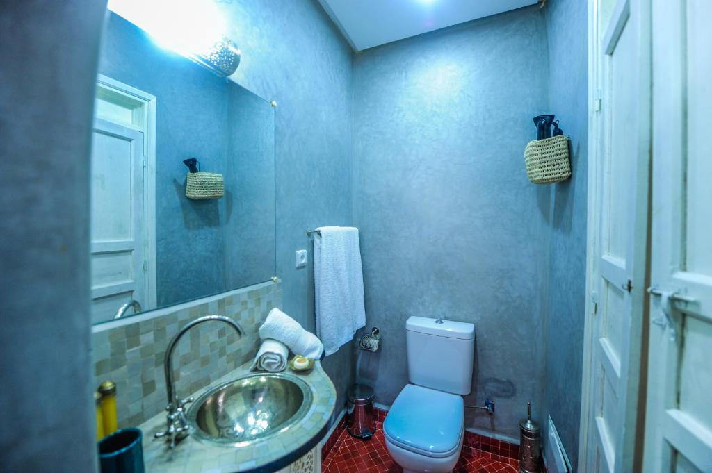 Moderns vannas istabas interjers ar pelēkām sienām, spoguli, izlietni un tualeti. Svaigi dvieļi un dekoratīvi elementi piešķir telpai mājīgumu.