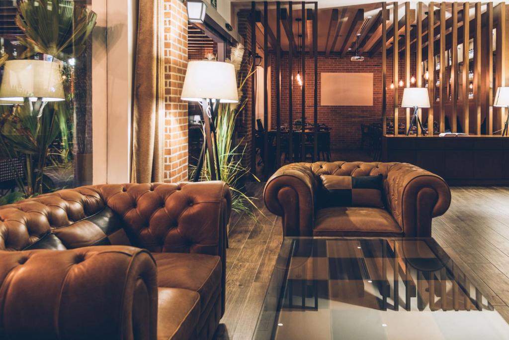 Eleganta kafejnīca ar komfortablām ādas dīvāniem, siltu apgaismojumu un mūsdienīgu interjeru, radot patīkamu atmosfēru. 