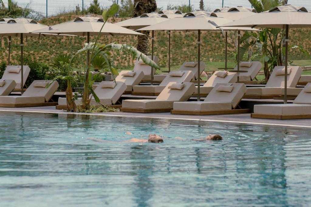 Viesnīcas LIU Resorts baseins ar sauļošanās krēsliem piekrastē.