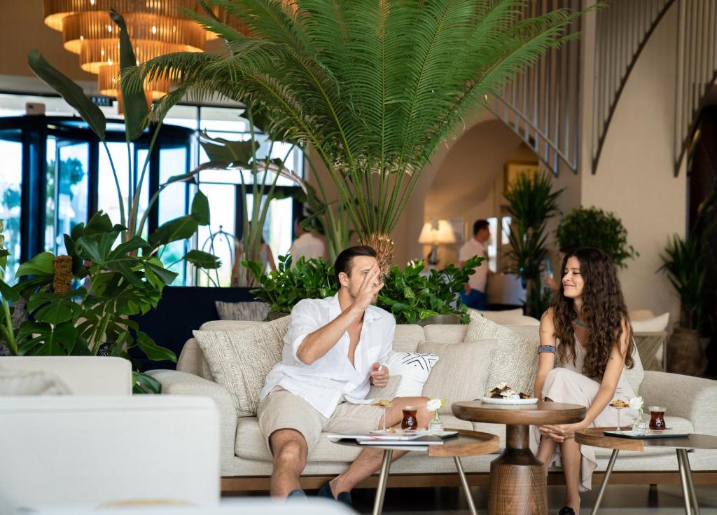 Pāris atpūšas viesnīcā LIU Resorts, baudot dzērienus un desertus.