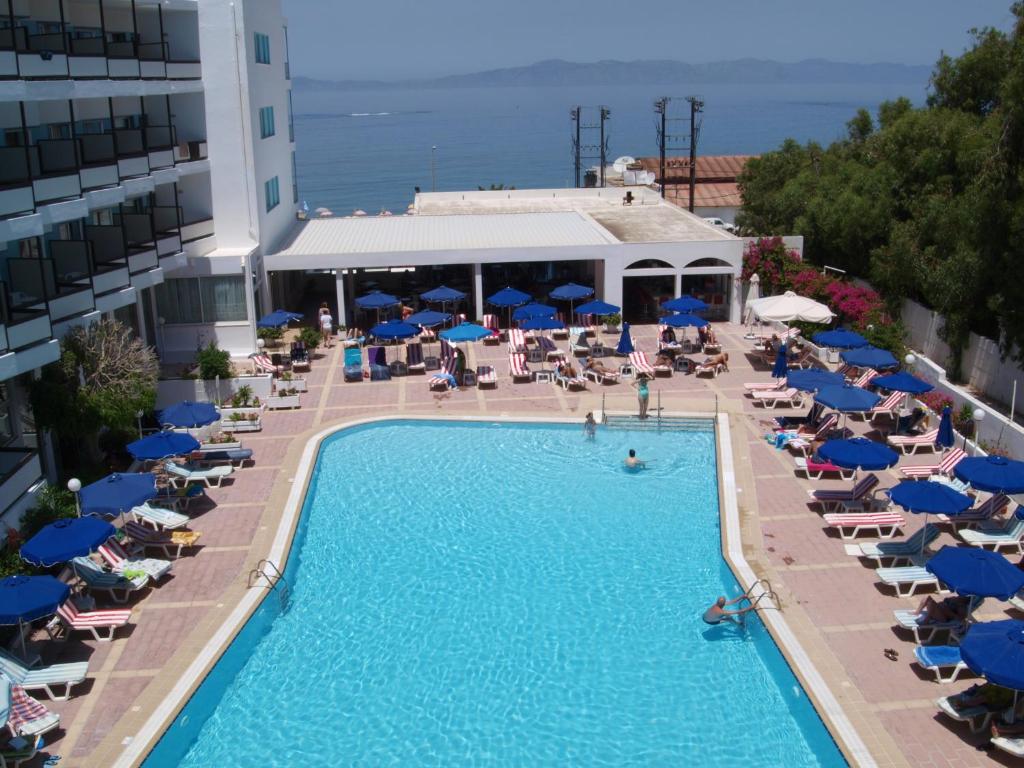 Viesnīcas Belair Beach baseins ar saules krēsliem un skatu uz jūru.