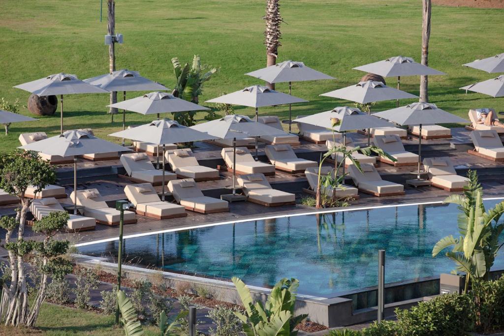 Viesnīcas LIU Resorts peldbaseins ar sauļošanās krēsliem un saulessargiem piekrastē