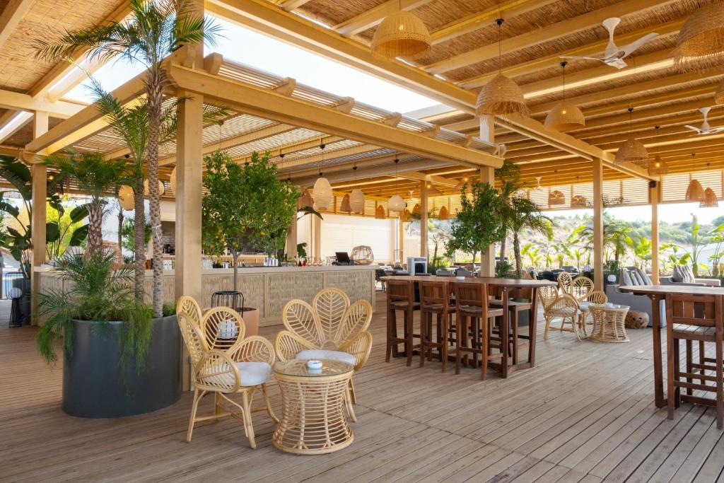 Pludmales bārs pie LIU Resorts ar ērtām mēbelēm un zaļumu.