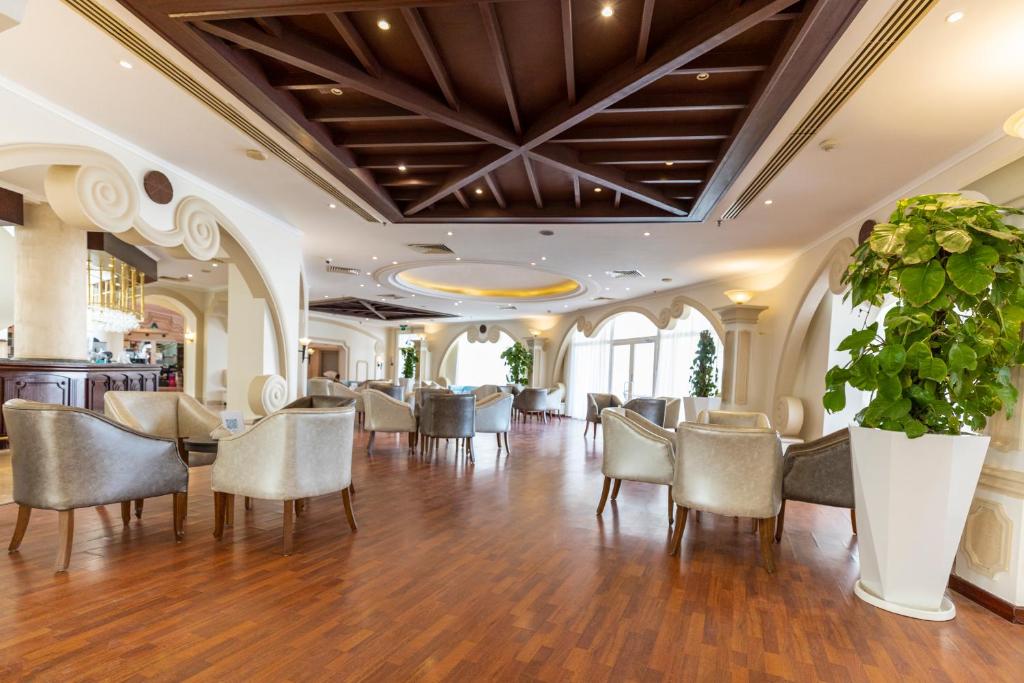 Eleganta atpūtas zona Sunrise Remal Resort ar moderniem krēsliem un apzaļumojumu.