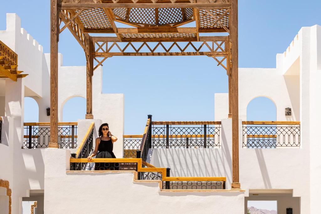 Viesnīcas Sunrise Remal Resort terase ar modernu arhitektūru un viesi.