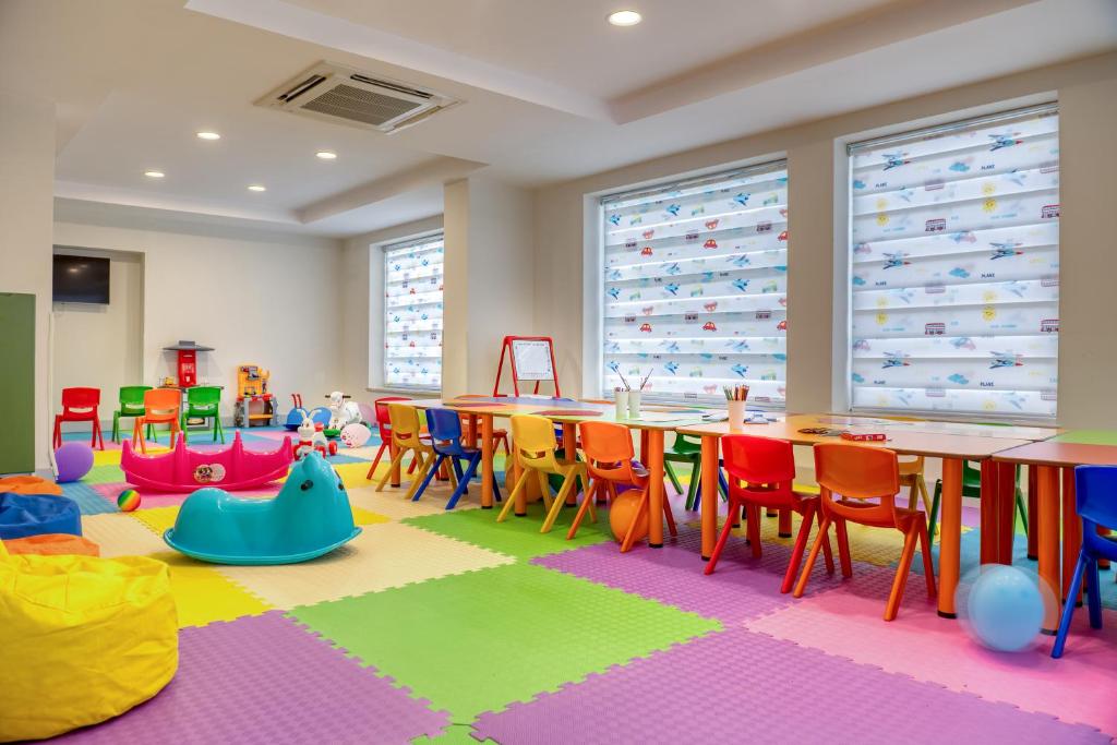 Bērnu rotaļu istaba viesnīcā Sealife Kemer Resort Hotel ar krāsainiem krēsliem un rotaļlietām.