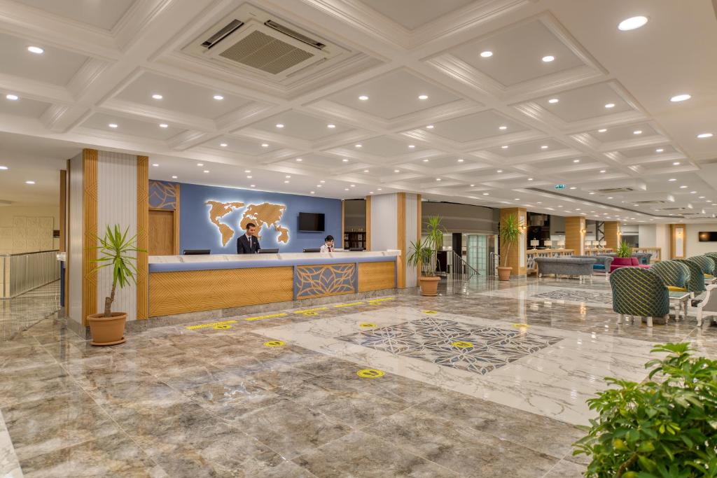 Recepcija Sealife Kemer Resort Hotel ar pasaulē karti un viesmīlīgu personālu.