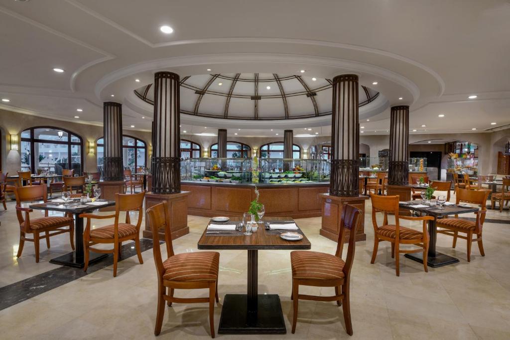 Iberotel Palace restorāns ar elegantiem galdiem un gaišu interjeru.