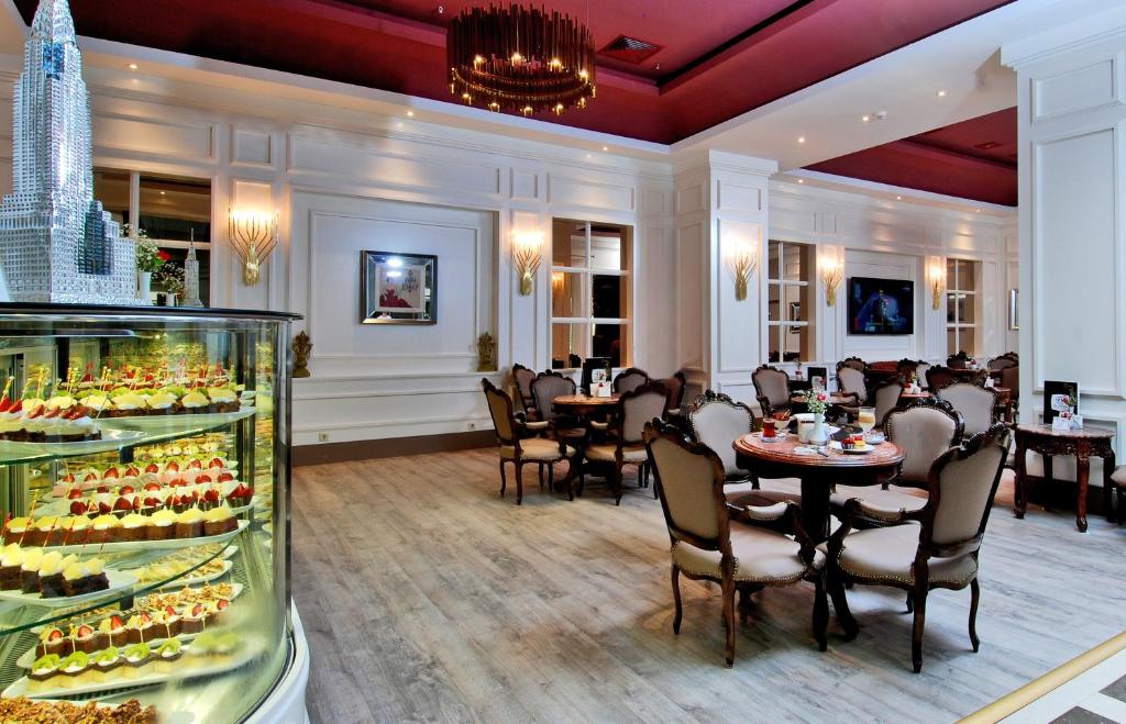 Mūsdienīgs restorāns ar elegantiem galdiem un kūku vitrīnu Delphin Diva