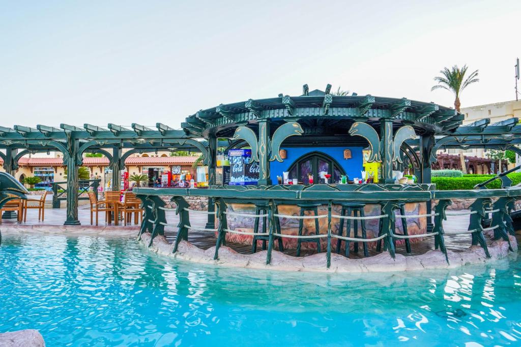 Peldbaseina bārs Charmillion Club Resort ar krāsainām dzērienu glāzēm
