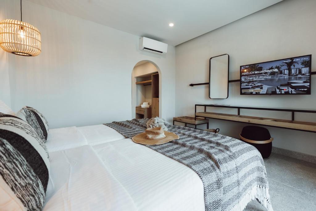 Mūsdienīgs viesnīcas numurs ar divām gultām, dekorēts ar stilīgām spilveniem un pludmales cepuri, kurā ir televizors un mēbeļu zona. Eleganta apgaismojuma un neitrālu toņu kombinācija rada mājīgu atmosfēru.