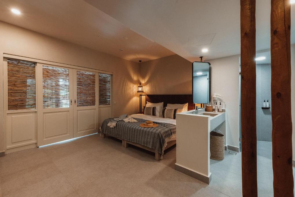 Mūsdienīga viesnīcas istaba ar divguļamo gultu, koka elementiem un elegantu apgaismojumu, kas rada siltu atmosfēru. Istaba ir aprīkota ar minimālistisku vannas istabu un dabiskā apgaismojumā caur austošajām žalūzijām.