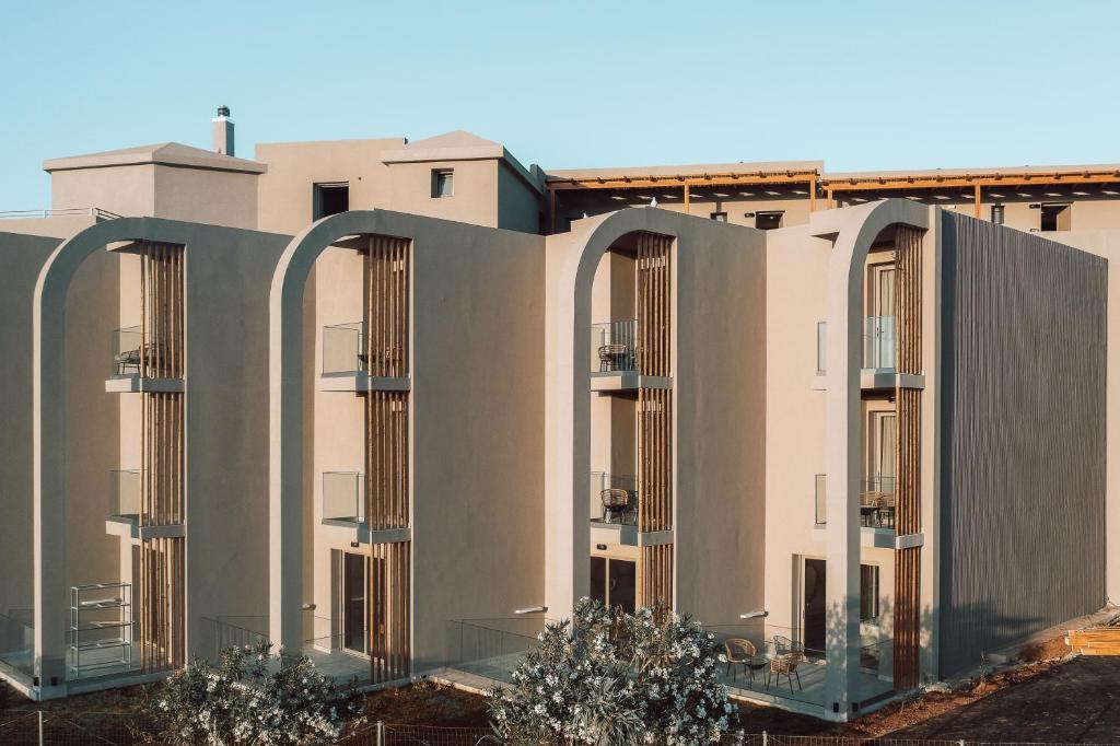 Mūsdienīga arhitektūra ar izteiksmīgām līnijām un balkoniem, kas veidota, izmantojot dabiskus materiālus. Ēka ir apzaļumota un atrodas gaismas apstākļos.