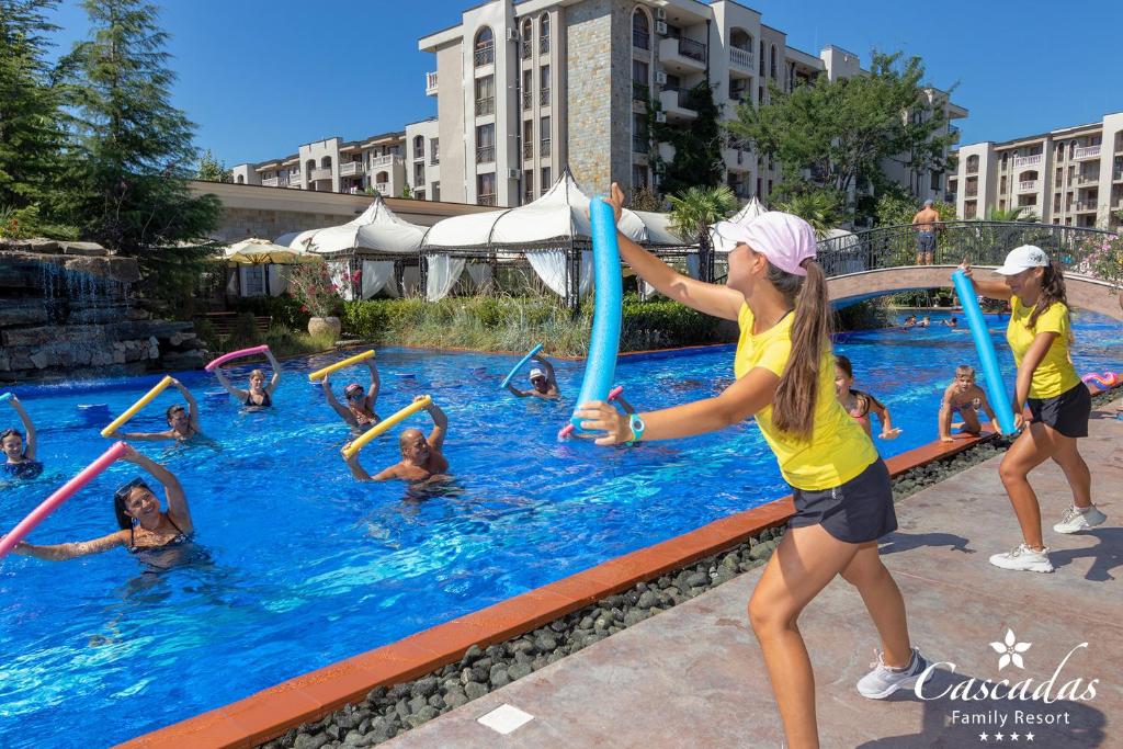 Vasaras aktīvās nodarbības baseinā ar ūdens nūjām, kur dalībnieki izbauda sportiskus vingrinājumus un trenējas kopā ar instruktoriem.